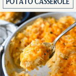 Spoon serving ultimate cheesy potatoes with text title box at top