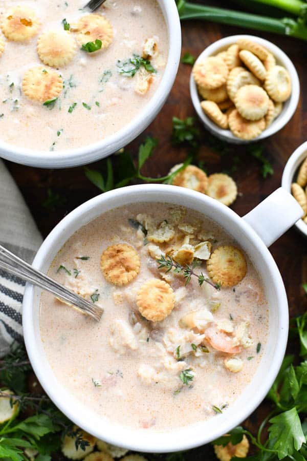 Creamy crab bisque soup in small ceramic bowls topped with mini oyster crackers.
