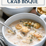 Front shot of easy crab bisque in a white bowl with text title box at top
