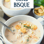 Close up shot of shrimp and crab bisque recipe in white bowls with text overlay