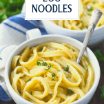 Close up side shot of homemade egg noodles in white bowls with text title overlay