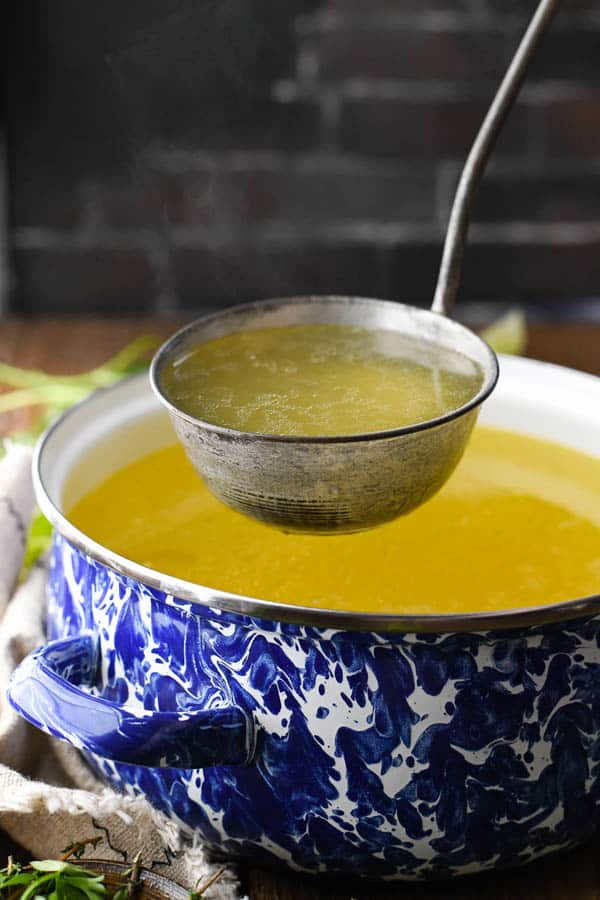Ladle scooping up the best chicken broth recipe