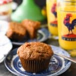 Front shot of the best morning glory muffins on a plate with orange juice in the background