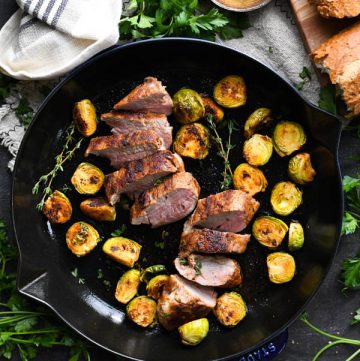 BBQ pork tenderloin in a skillet with crispy Brussels sprouts