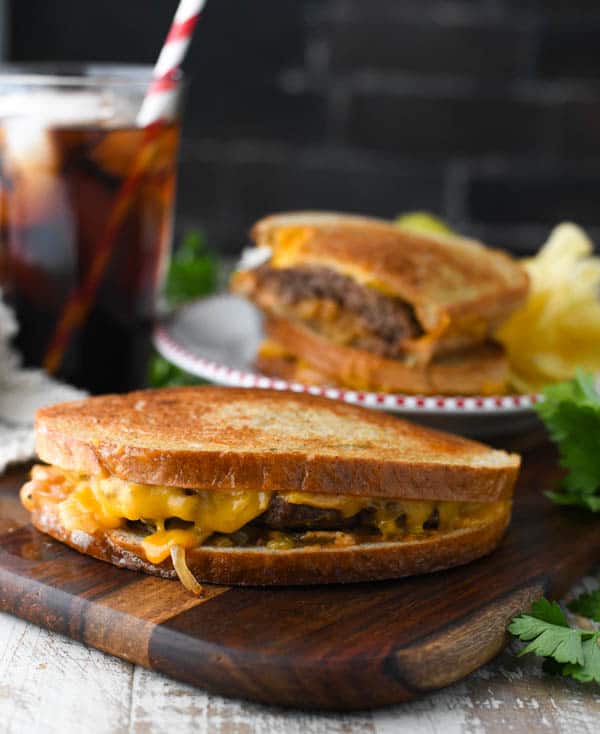 Close up shot of a patty melt on a wooden cutting board