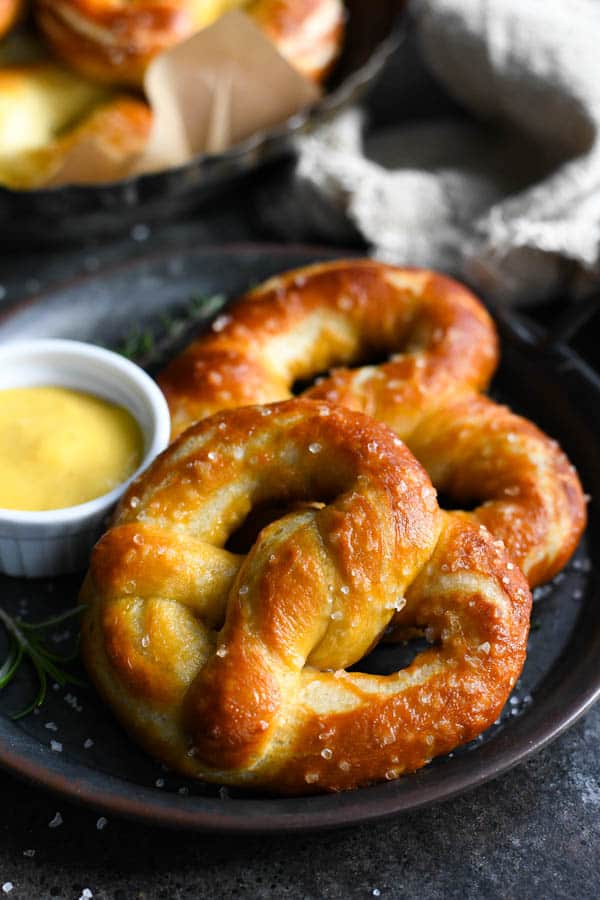 Side shot of two homemade soft pretzels on a plate