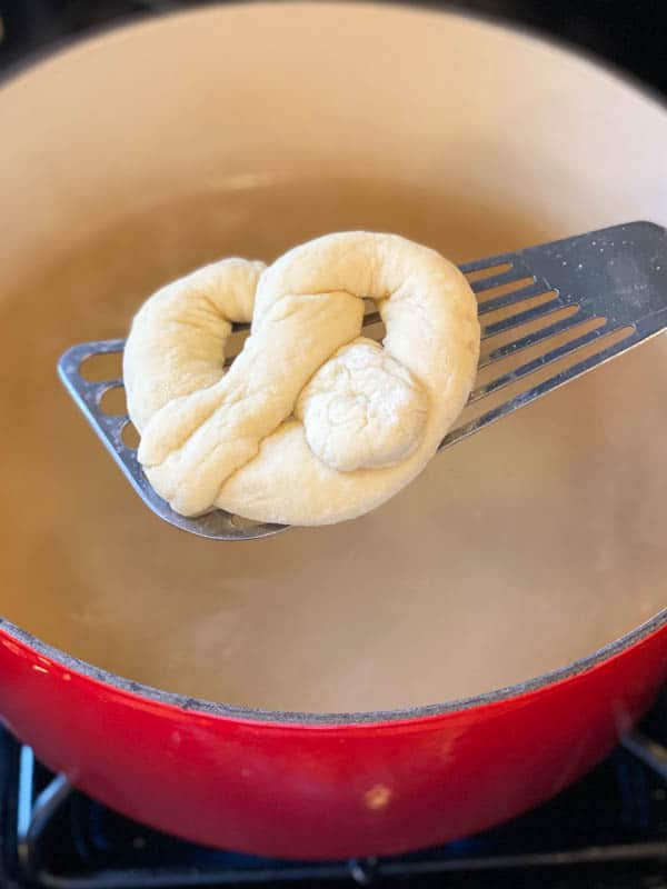 Process shot showing how to make homemade soft pretzels with a baking soda bath