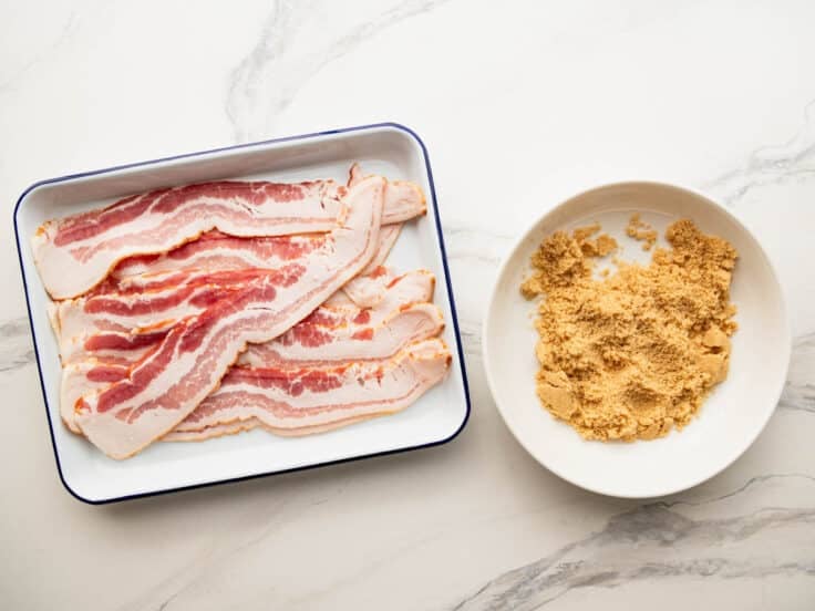 Ingredients for candied bacon on a white marble table.