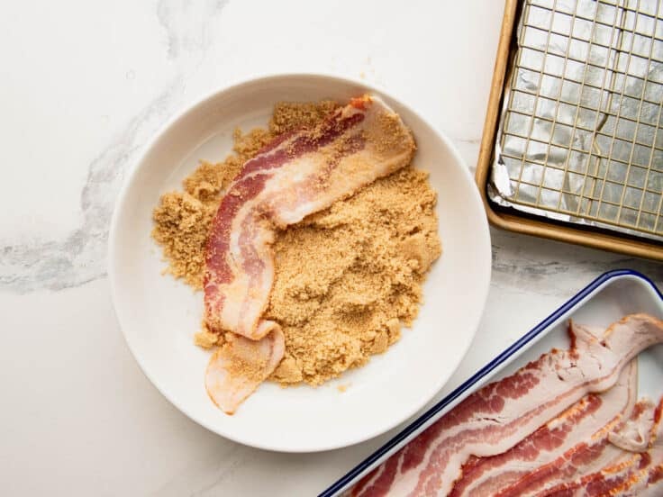Process shot showing how to coat bacon in brown sugar.