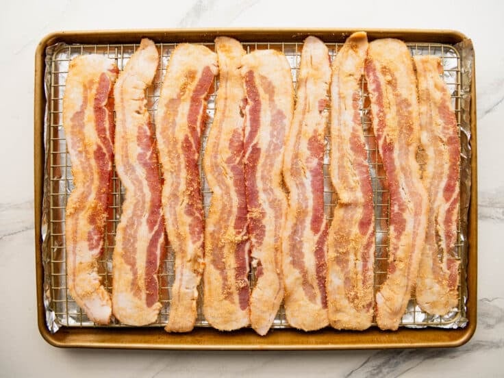 Arranging bacon on a wire rack.