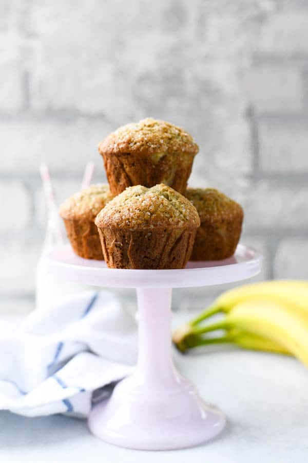 Front shot of moist banana muffins on a pink cake stand