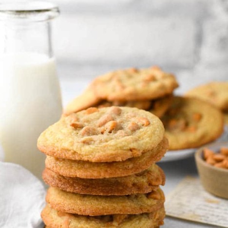 Stack of butterscotch cookies in front of a glass of milk