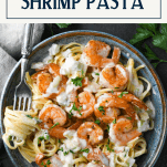 Overhead shot of a bowl of creamy shrimp pasta with text title box at top