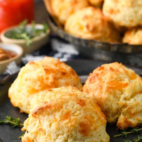 Close up side shot of fluffy cheese drop biscuits on a plate