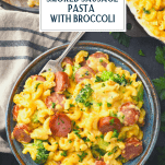 Overhead shot of a bowl of skillet mac and cheese with smoked sausage and text title overlay