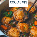 Wooden spoon in a pot of coq au vin with text title overlay