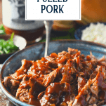 Side shot of a bowl of crock pot dr pepper pulled pork with text title overlay