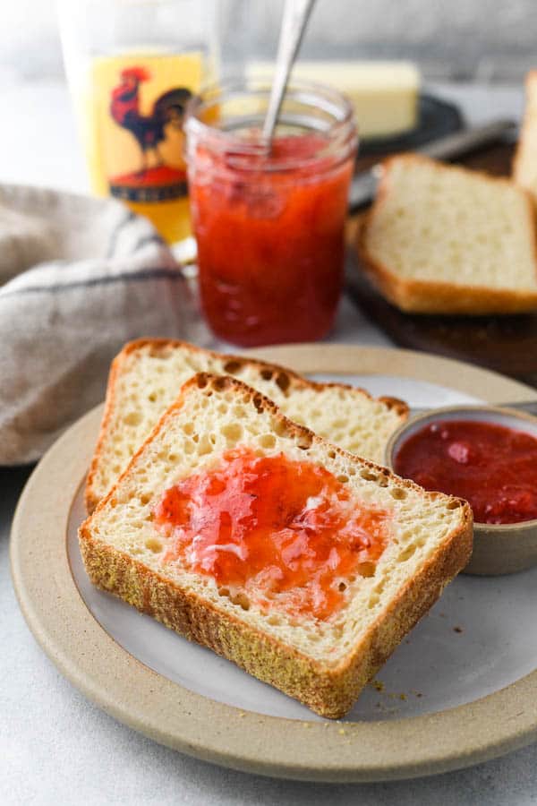 English muffin toasting bread on a plate with butter and jam