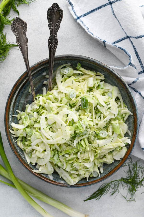 Overhead shot of shaved fennel slaw with apples and a creamy homemade dressing