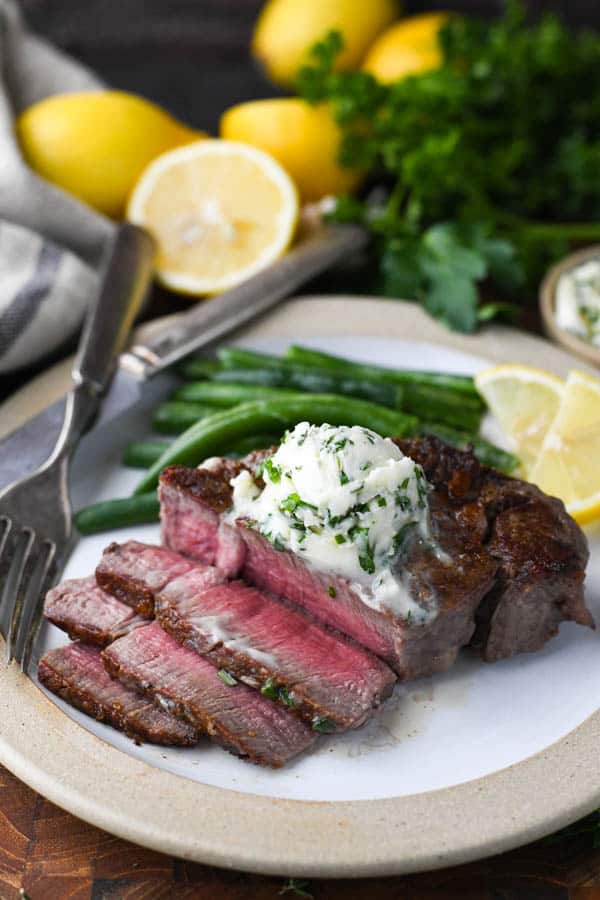 Sliced filet mignon on a plate with garlic herb butter