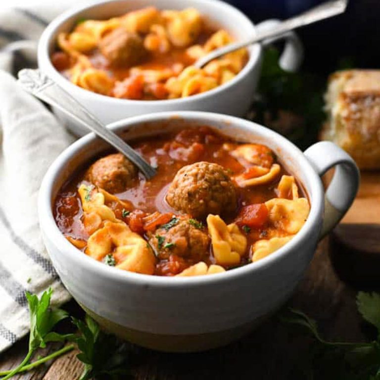 Square side shot of two bowls of meatball soup with tortellini