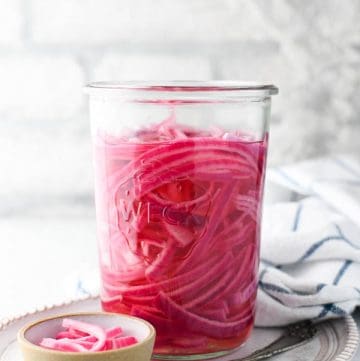 Front shot of homemade pickled red onions in a glass jar