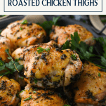 Close up shot of herb roasted chicken thighs on a platter with text title box at top
