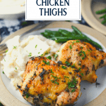 Front shot of a plate of oven roasted chicken thighs with text title overlay