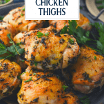 Platter of crispy roasted chicken thighs with text title overlay