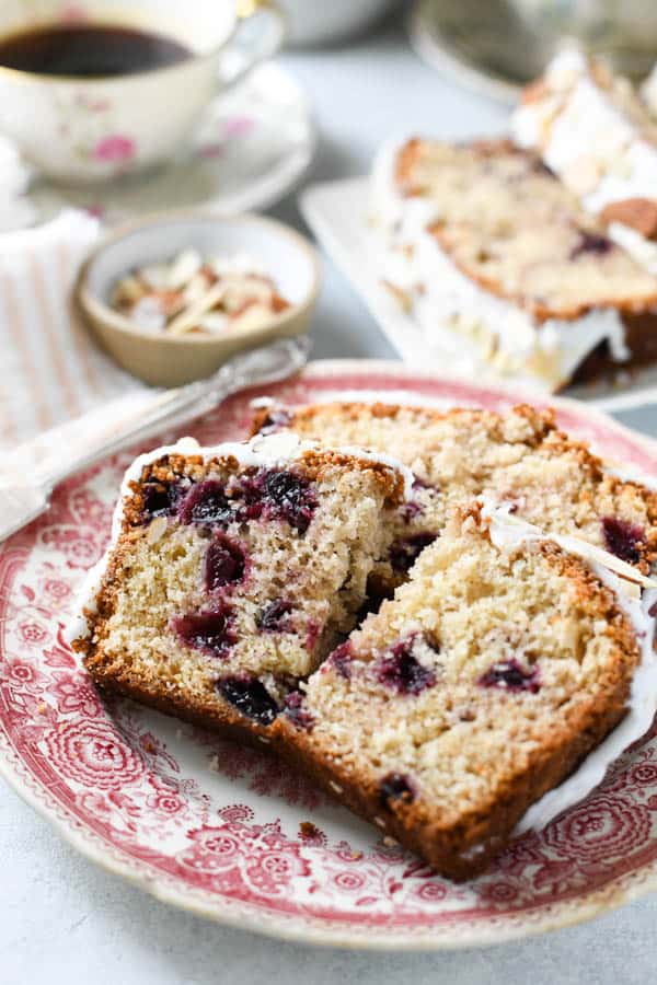 Slices of almond cherry bread on a red and white plate.