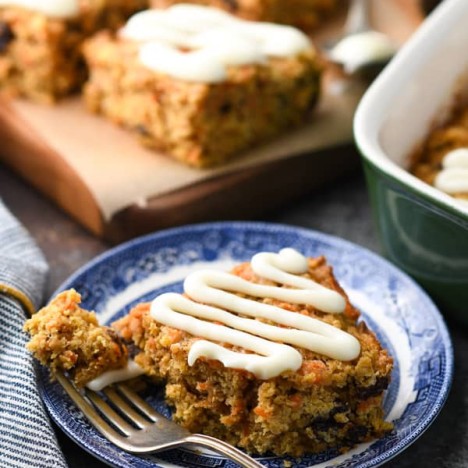 Close up side shot of homemade carrot cake baked oatmeal bars with a cream cheese glaze.