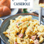 Close up side shot of a bowl of creamy chicken cordon bleu casserole with text title overlay