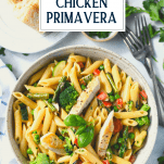 Overhead shot of a bowl of creamy chicken primavera with text title overlay
