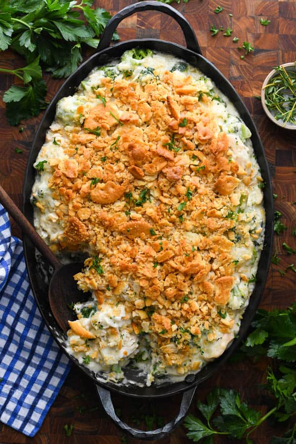 An overhead shot of a large, oval casserole dish of chicken and broccoli with rice, topped with crushed Ritz crackers. 