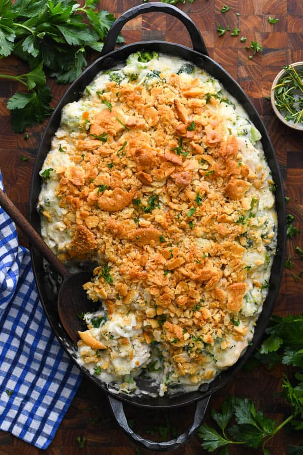 An overhead image of a casserole dish filled with fresh baked chicken and broccoli rice casserole, topped with crumbled Ritz crackers.