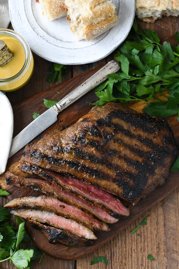 Overhead image of grilled flank steak with bourbon glaze on a wooden cutting board