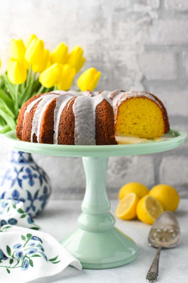 Front shot of an easy lemon bundt cake using cake mix on a green cake stand