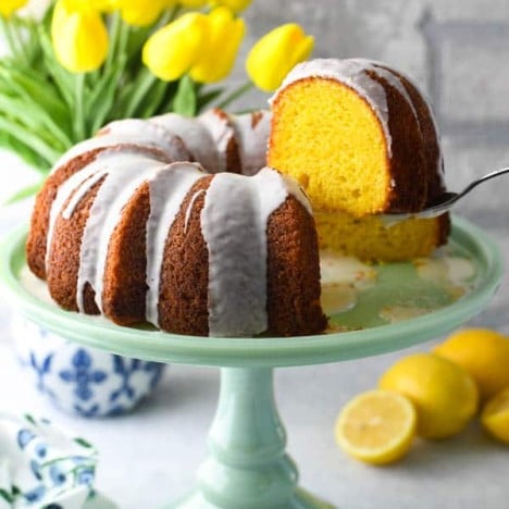 Cake server lifting a slice of the best Lemon Bundt Cake from cake mix