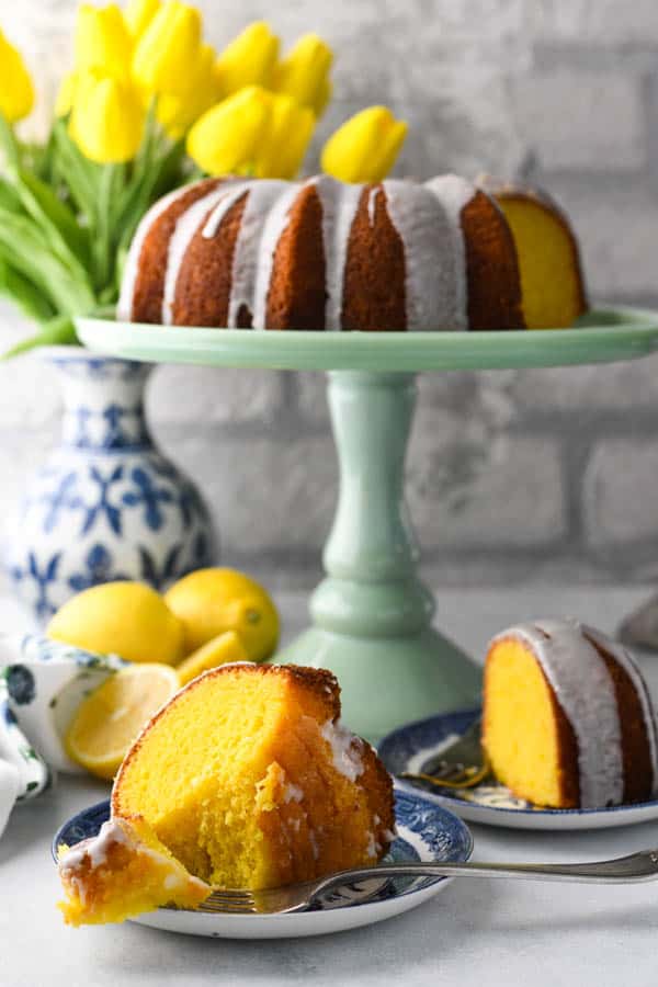 Two slices of Lemon Bundt Cake from cake mix on a white surface in front of a white brick wall