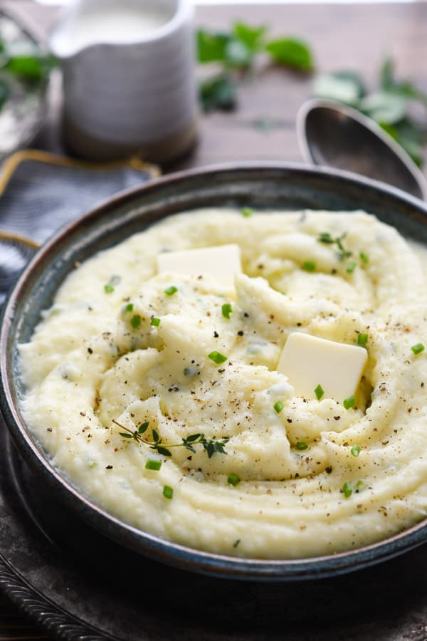 Close up side shot of a bowl of creamy mashed potatoes