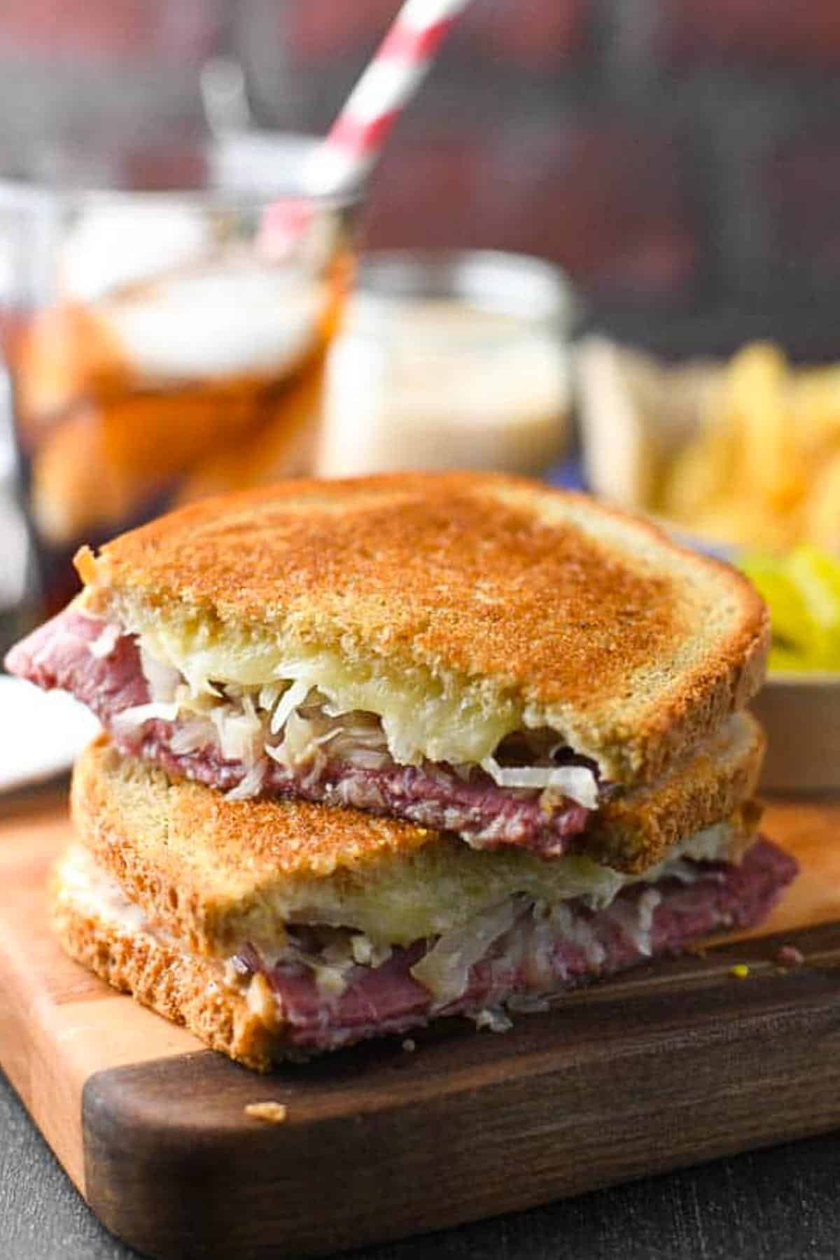 Side shot of a classic reuben sandwich on a cutting board.