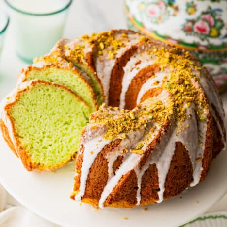 Square side shot of a pistachio cake recipe with cake mix on a white cake stand.