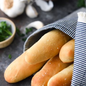 Close up side shot of Olive Garden breadsticks wrapped in a blue and white cloth