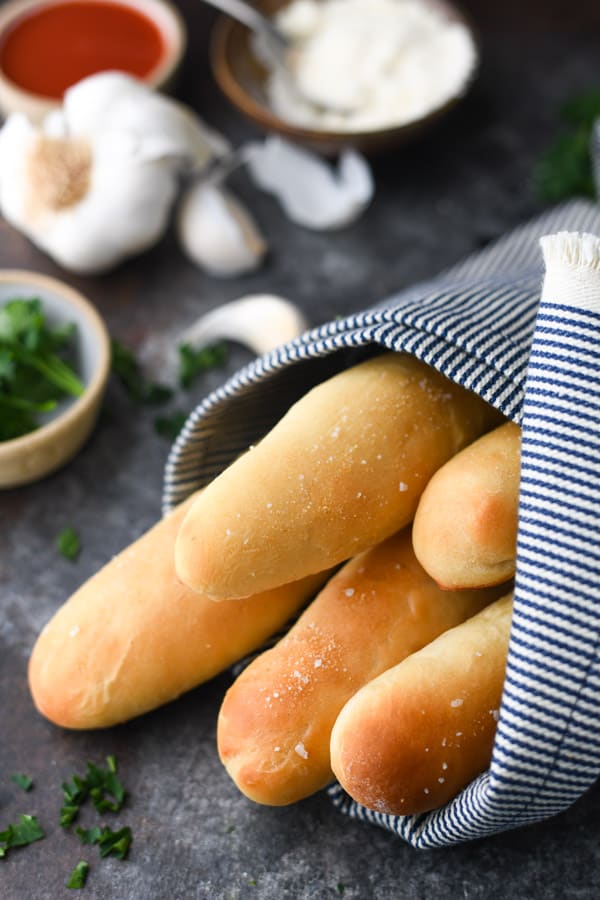 Close up side shot of Olive Garden breadsticks wrapped in a blue and white cloth