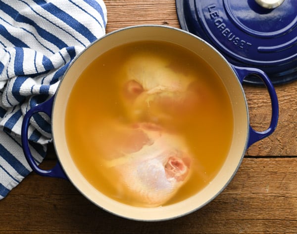 Two chicken breasts in a pot of broth