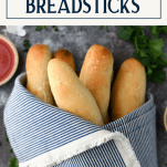 Garlic breadsticks in a blue and white cloth with text title box at top
