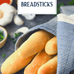 Garlic breadsticks wrapped in a towel with text title overlay