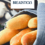 Homemade breadsticks wrapped in a towel with text title overlay