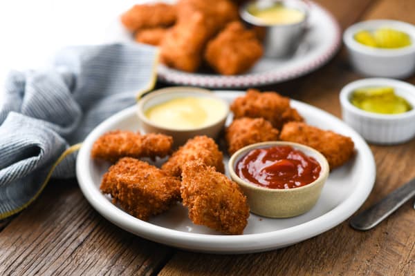 Horizontal shot of a plate of the best chicken nuggets on a wooden table