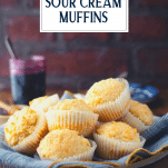Side shot of a basket of sour cream muffins with text title overlay